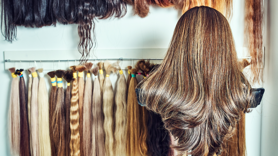 Woman choosing loose wave hair bundles from a display of human hair extensions in multiple textures and lengths